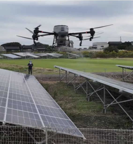 太陽光パネル上のドローンと作業員